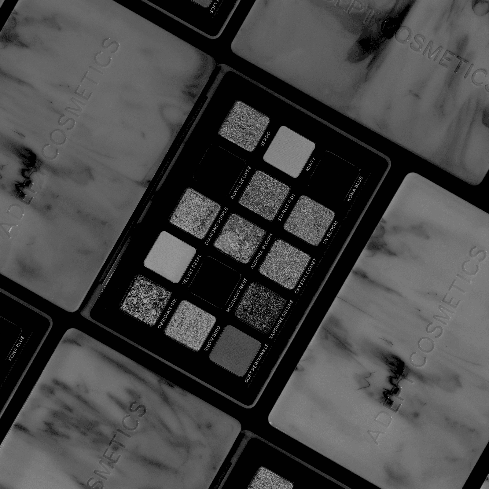 Makeup palette with multiple shades on a marble surface, featuring the brand 'Buro Cosmetics'.