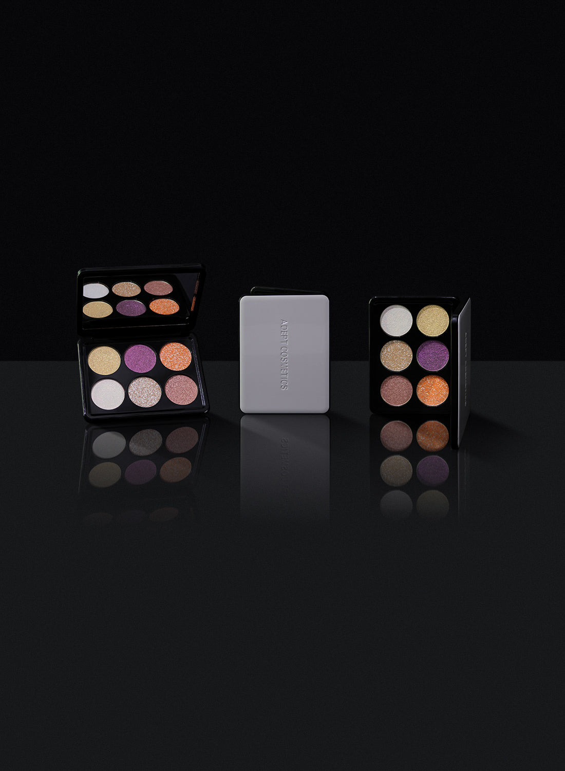 Two makeup palettes with colorful shades and a white square in the center on a black background.
