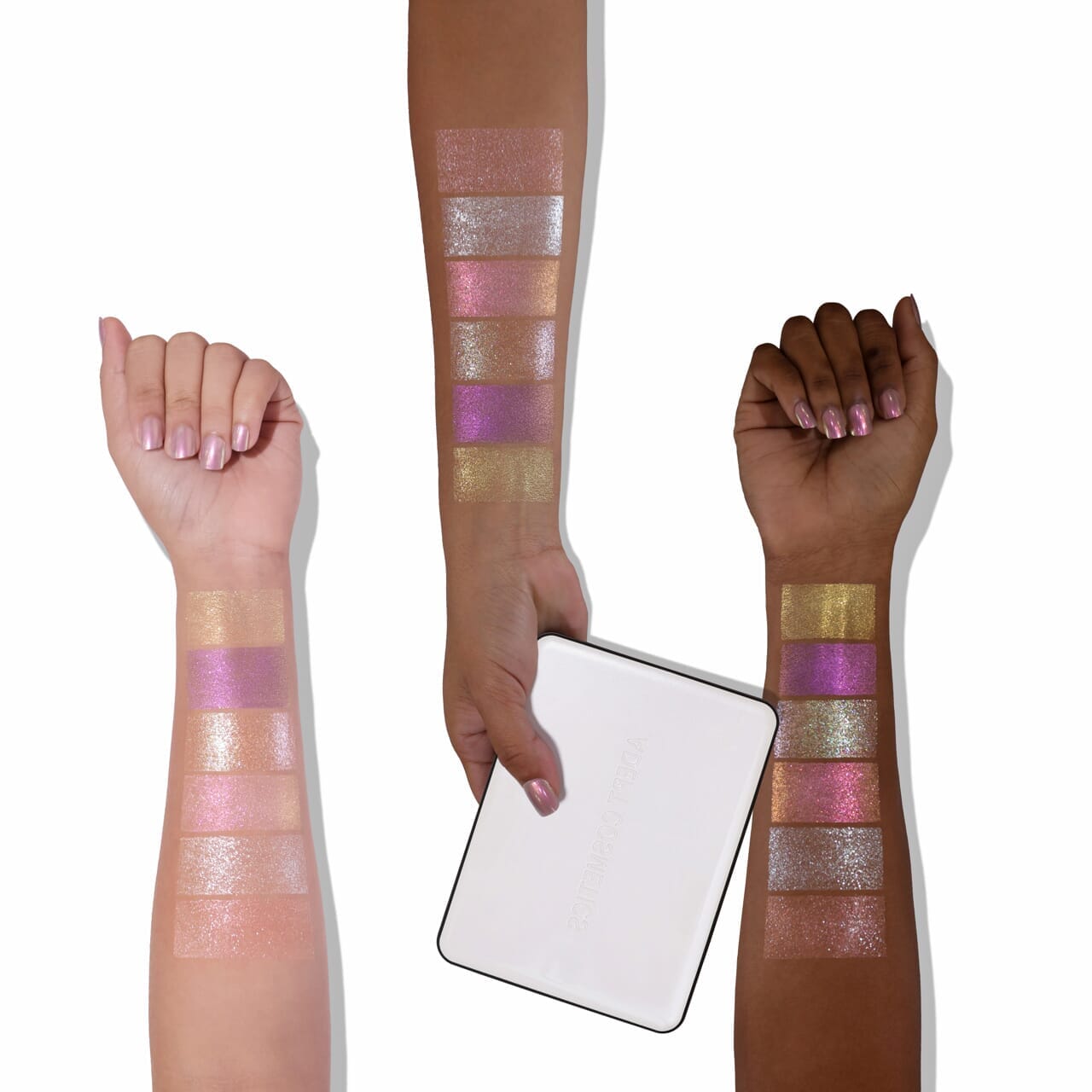 Three arms with colorful glittery makeup swatches on a white background